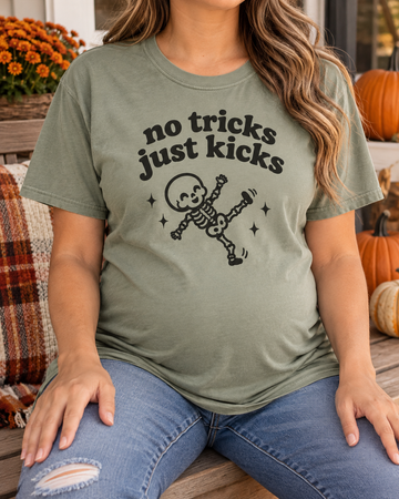 Pregnant model wearing No Tricks Just Kicks skeleton Comfort Colors tee in Sage